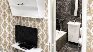 Ein modernes Badezimmer mit einem weißen Waschtisch, einem schwarzen Becken und einem Boden aus Marmorplatten.