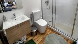 A modern bathroom with a shower, toilet, and sink. - S.K.Y. Accommodations Family studios  (Coimbra)