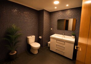 Un bagno con WC, lavandino e specchio.