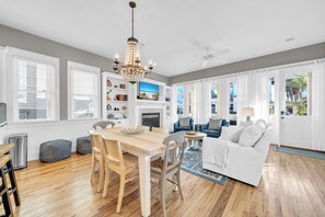 A spacious living room with a fireplace, a dining area with a wooden table and chairs, and a seating area with a sofa and armchairs. - When you need a getaway, Beach Therapy is the cure! (Panama City Beach)