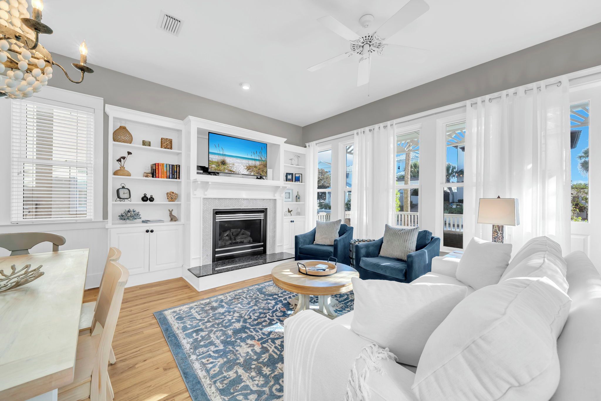 A modern living room with a fireplace, a television, and a view of the outdoors.