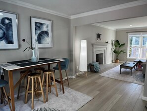 Un comedor con una mesa, sillas y una obra de arte en la pared.