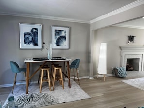 Uma área de refeições com mesa, cadeiras e uma obra de arte na parede.