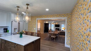A kitchen with white cabinets, a marble countertop, and a dining area with wooden chairs and a table. - Spacious 2-bedroom + office home in beautiful Idaho Falls-30 day minimum (Idaho Falls)