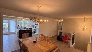 Eine geräumige Küche mit Essbereich, Holzmöbeln und einer Treppe, die zu einer weiteren Ebene führt.