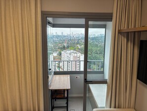 Ein Balkon mit Blick auf die Stadt, ein kleiner Tisch und ein Stuhl.
