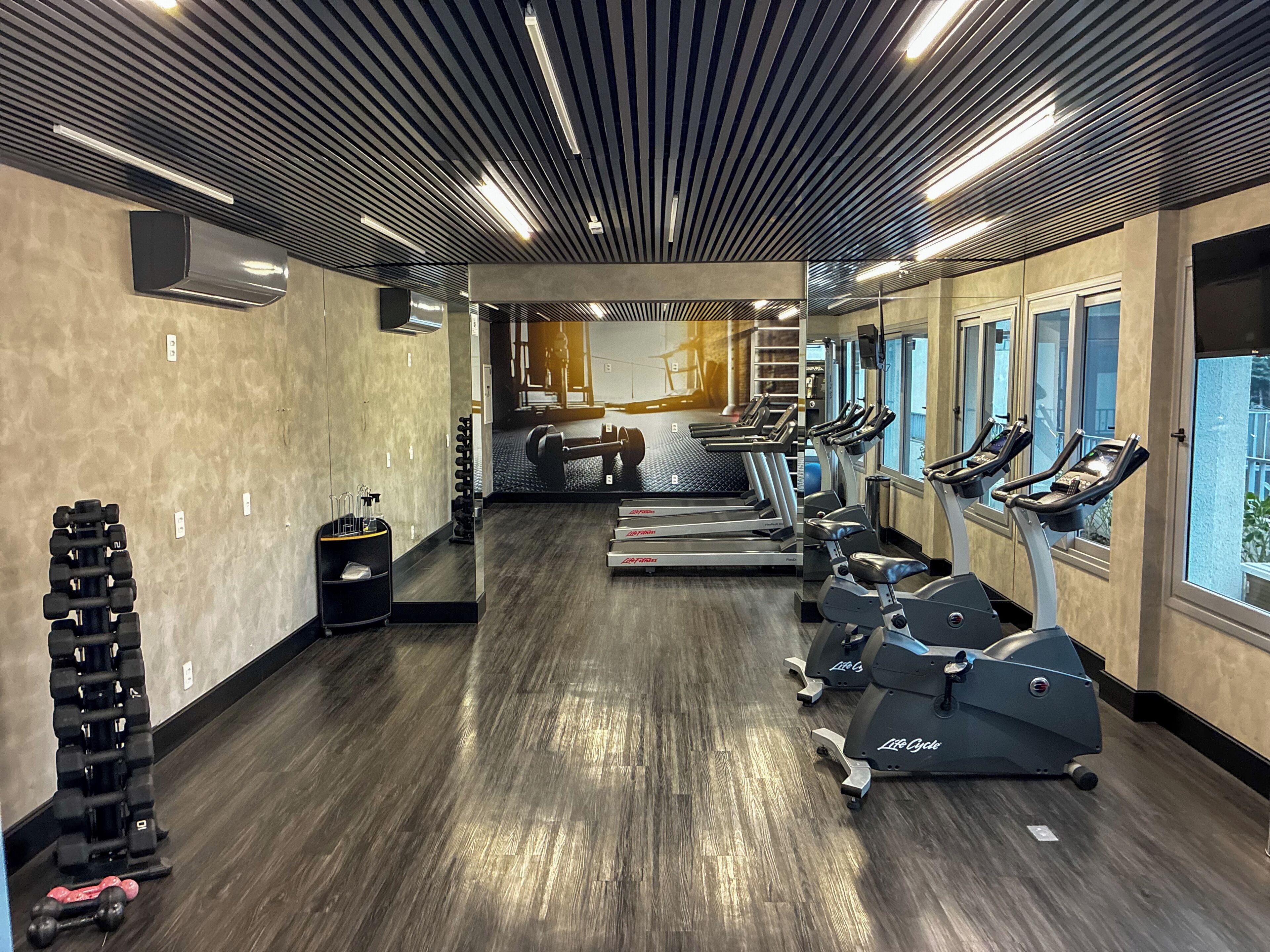 Una palestra con tapis roulant, ellittiche e pesi.