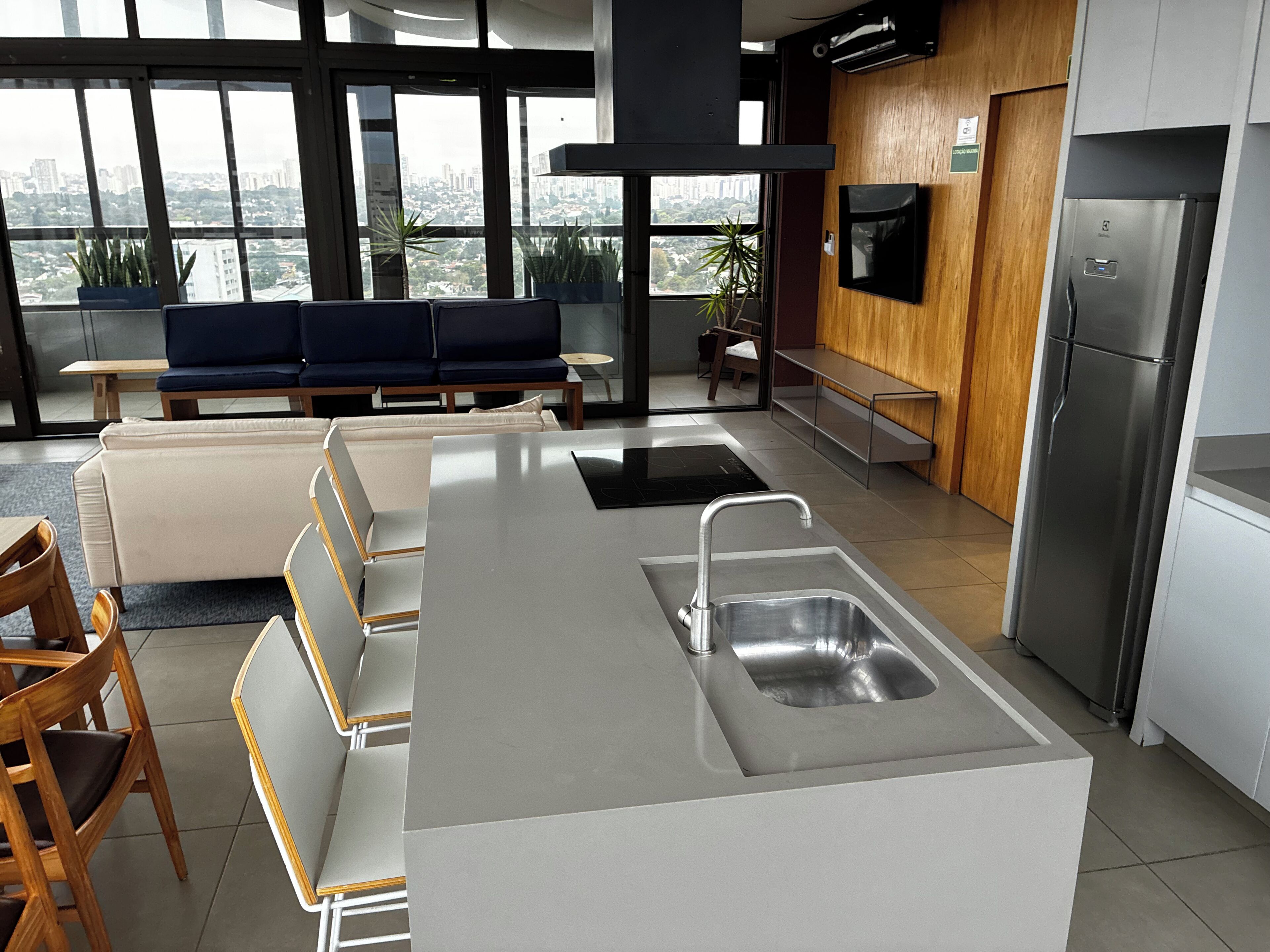 A modern kitchen with a built-in island, stainless steel appliances, and a seating area with a view.