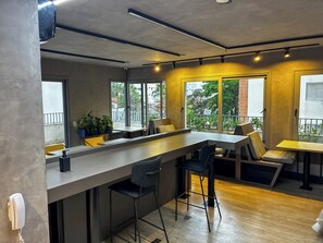 A modern interior with a bar area, seating, and large windows. - Be Urban (São Paulo)