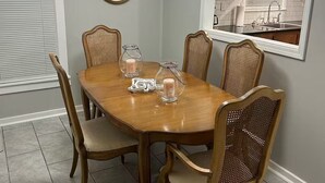 Ein Esszimmer mit einem Holztisch, sechs Stühlen und einer Kronleuchter.
