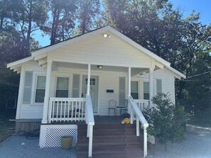 A small, single-story house with a porch, a front door, and a small set of stairs leading up to the entrance. - Pixie’s Haven A Home Away From Home (Monroe)