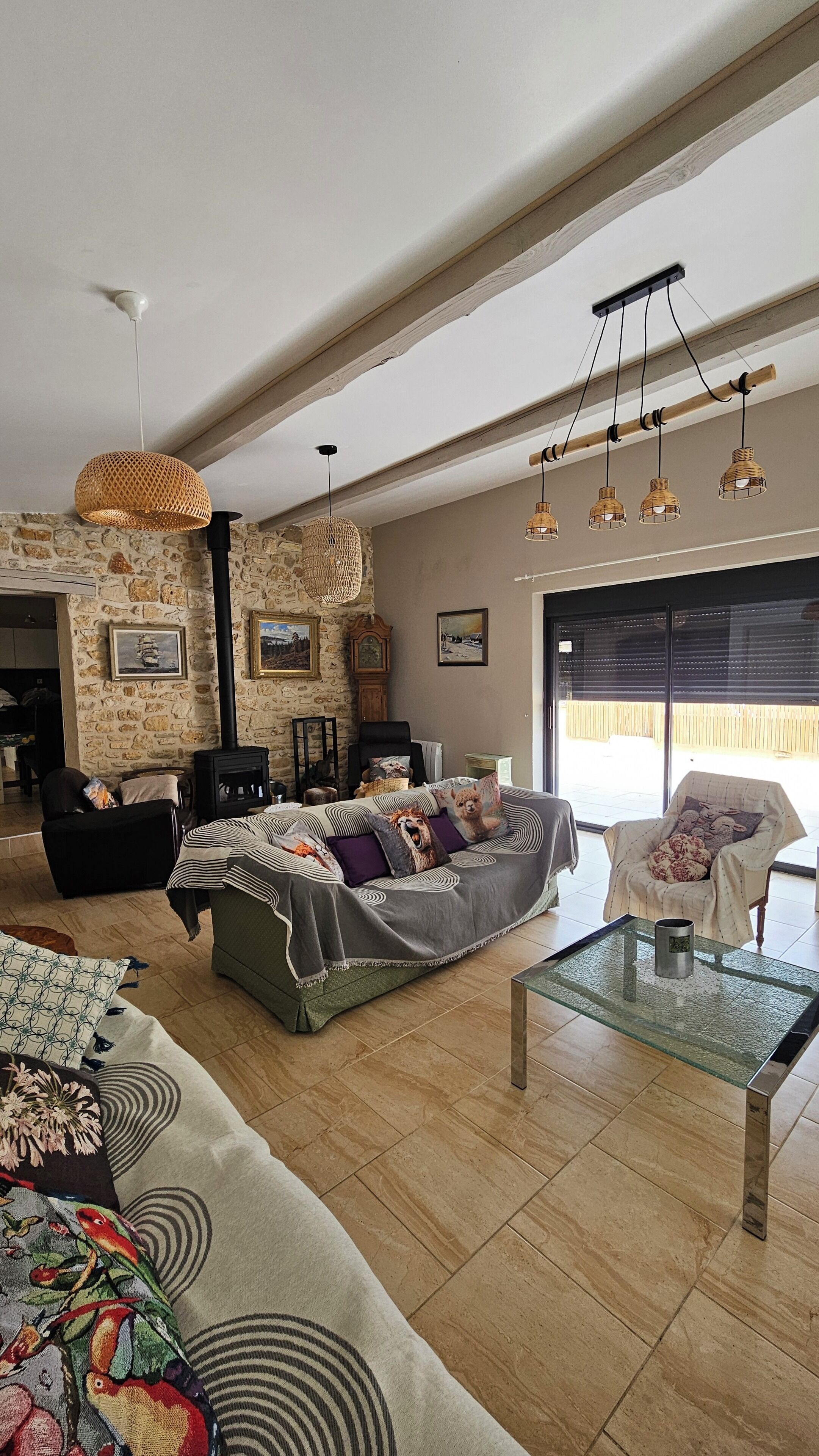 A spacious living room with a sofa, a glass coffee table, and a fireplace.