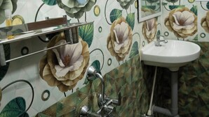 A bathroom with a sink, mirror, and shower. - RMA Joliday Inn (Pondicherry)