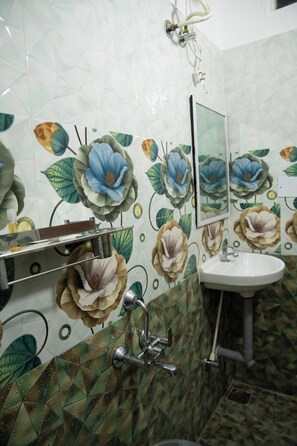 Een badkamer met een wastafel, spiegel en douche.