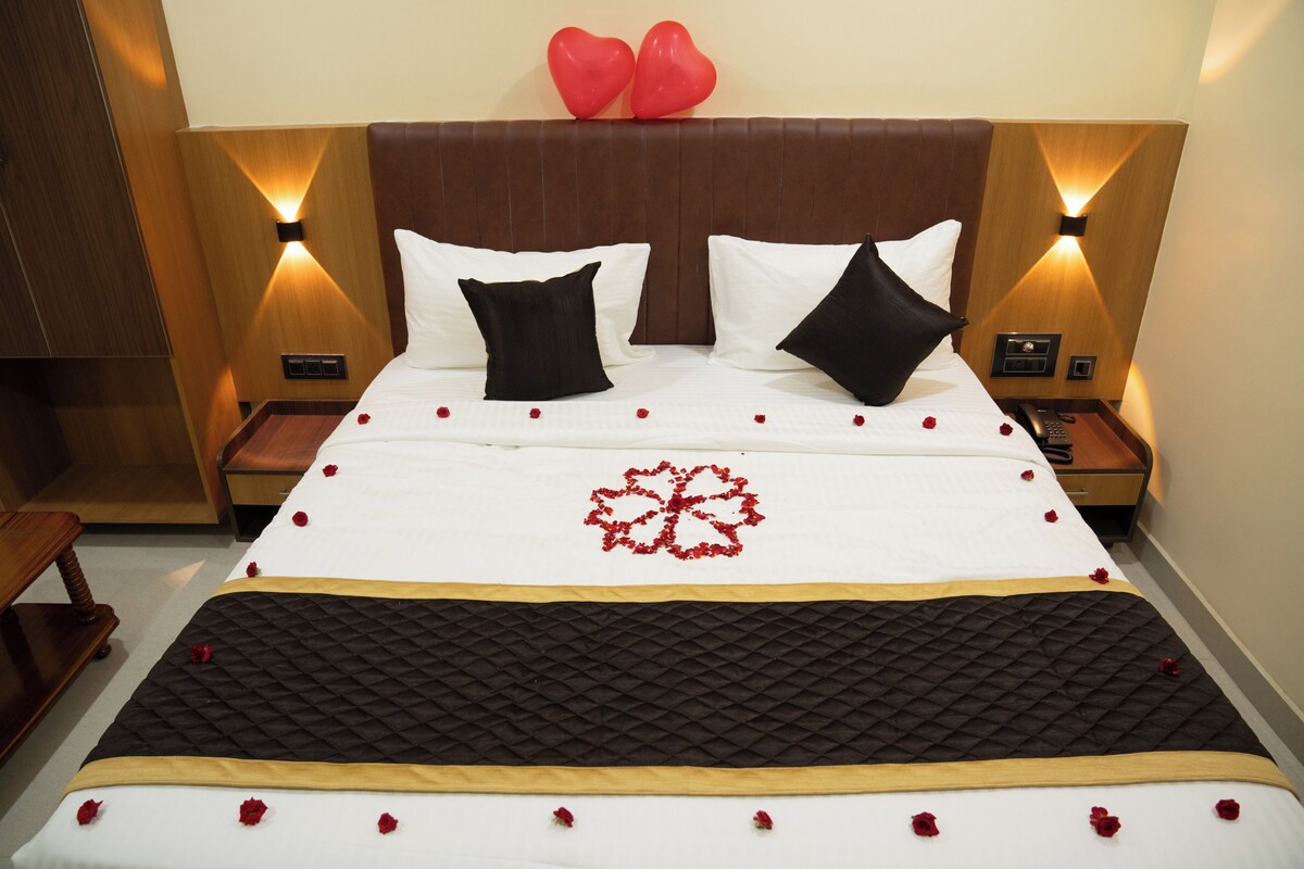 Een hotelkamer met een bed, twee nachtkastjes, een houten hoofdbord en een wandlamp.