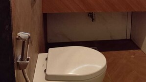 Et badeværelse med toilet, vask og spejl med lys langs kanten.
