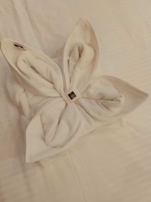 Una toalla blanca doblada con cuidado, con una etiqueta pequeña colocada sobre una superficie blanca lisa.