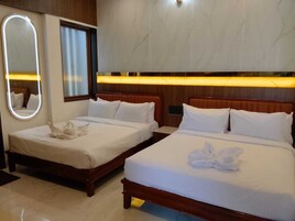 Una habitación de hotel con dos camas, un espejo grande y un cabecero de madera.