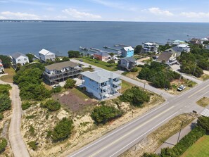 An aerial view of a coastal residential area with houses, a road, and a body of water. - Emerality | Steps to Beach, Private Elevator (Emerald Isle)