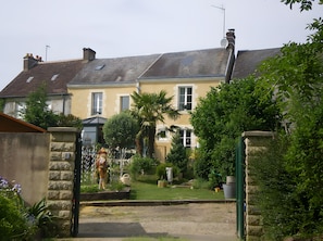 A residential building with a sloped roof, a satellite dish, and a gated entrance.