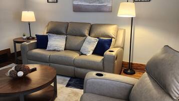 A living room with a sofa, two side tables, a coffee table, and a rug.