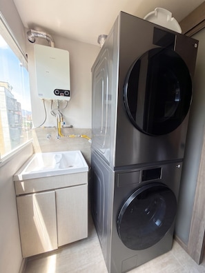 A compact laundry room with a washing machine, dryer, and a water heater. - lEPl Big & Elegant 3 Bd Apt W/Ac Near provenza (Medellín)