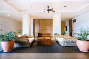 Une chambre d’hôtel avec un lit, un banc en bois et deux plantes en pot.