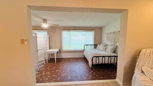 Ein Schlafzimmer mit einem Bett, einem Schreibtisch und einem Fenster.