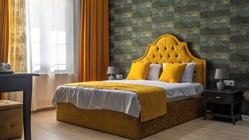 Une chambre à coucher avec un grand lit, une table de chevet, une lampe, une fenêtre avec des rideaux et un tapis à motifs.