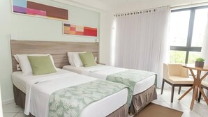 Ein Hotelzimmer mit zwei Betten, einem kleinen Tisch und einem Stuhl.