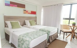 A hotel room with two beds, a small table, and a chair. - Enjoy Beachfront Bliss at Family Suite Near Tambau Beach - Free Breakfast! (Paraíba)