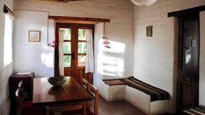 Un comedor rústico con una mesa de madera, sillas y un banco.
