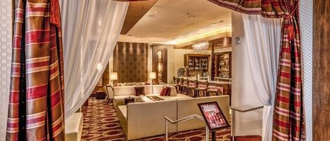Un hall de hotel con una zona de estar, un bar y vistas al área del bar.