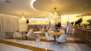 Un restaurante moderno con mesas y sillas redondas, un mural con un paisaje urbano en la pared y vistas del horizonte de la ciudad.