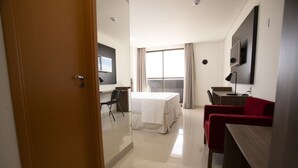 A hotel room with a bed, a desk, a chair, and a TV. - Relaxing Room Perfect for Families and Leisure Travelers Visiting Araripina (Pernambuco)