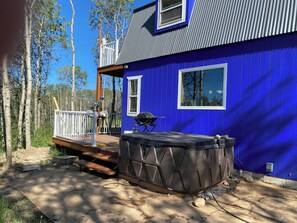 A blue house with a deck, a hot tub, and a grill. - Glacier Aurora - Stargazing Wonder overlooking the Forest and the East Rockies (Babb)