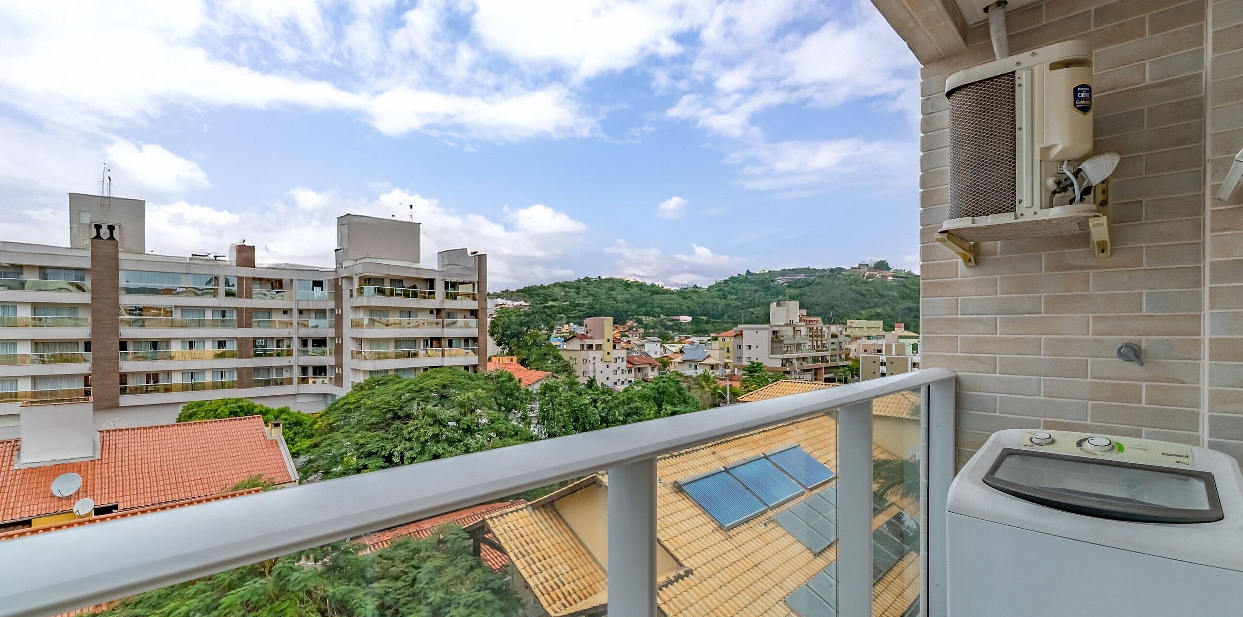 Un balcón con vista a un paisaje urbano, un calentador de agua y un panel solar en el techo.