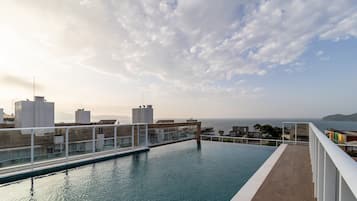 Una piscina infinita con vista al mar y edificios.