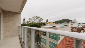 A balcony with a view of a cityscape, including buildings and a hill. - Studio 350m From Beach Bombinhas Vec213 (Bombinhas)