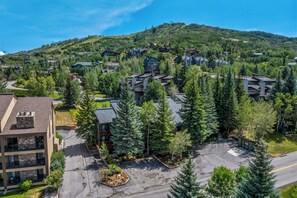 A residential area with multiple buildings, a parking lot, and a mountainous backdrop. - Mountain Comfort at Ski Ranch 103 – Easy Access to Slopes & Town! (Steamboat Springs)