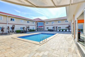 A swimming pool with a tiled deck, surrounded by a building with multiple windows and a red roof. - Pet-Friendly Stay | Near Jundiaí Industrial Zone & Parque da Cidade (São Paulo)