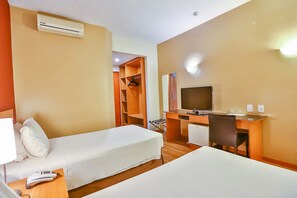 A hotel room with two single beds, a desk with a chair, a television, and a wardrobe. - Spacious Suite | Outdoor Pool | Near Rota Turística da Uva (São Paulo)