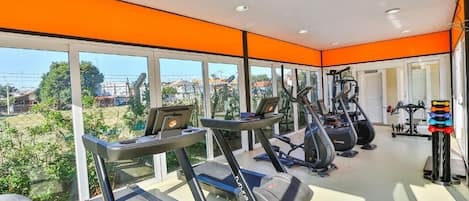 A gym with treadmills, elliptical machines, and weight equipment.