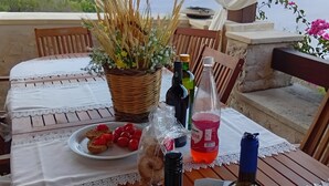 Ein Tisch im Freien mit einer Prosecco-Flasche, einem Weinglas und einem Teller mit Essen.
