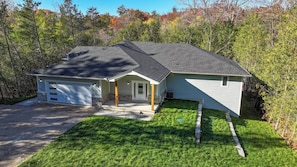 A single-story house with a garage, a covered porch, and a well-maintained lawn. - Executive Cottage on Lakeview HotTub Firepit Sauna Nearby Walking Nature Trails (Lambton Shores)