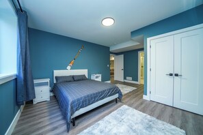 A bedroom with a bed, nightstands, a wardrobe, and a ceiling light. - Executive Cottage on Lakeview HotTub Firepit Sauna Nearby Walking Nature Trails (Lambton Shores)