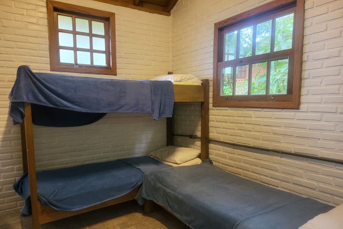 A bunk bed room with a window and a brick wall.