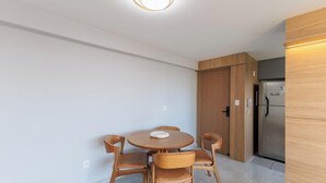 A modern kitchen with a built-in refrigerator, wooden cabinets, and a round dining table with chairs. - Sea View Apartment 300m From the Beach Mmd0403 (Ilhéus)