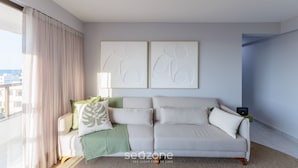 A modern living room with a sofa, a lamp, and abstract wall art. - Sea View Apartment 300m From the Beach Mmd0403 (Ilhéus)