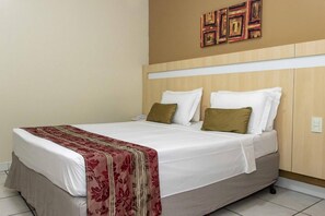 A hotel room with a bed, white bedding, a red and gold throw blanket, and a wooden headboard. - Peaceful, Airy Unit in a Prime Location Near Belém’s Highlights + Pool Access (Pará)